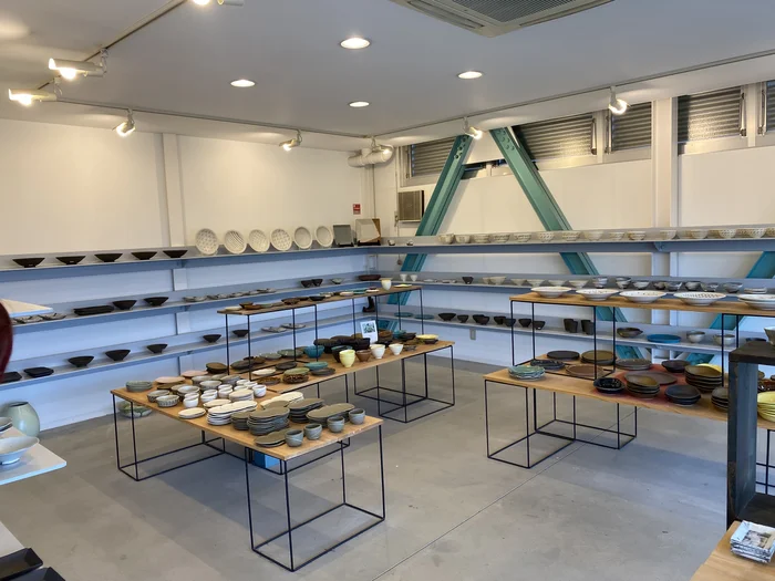 緑のA字梁が印象的な広いフロアに器が並ぶ