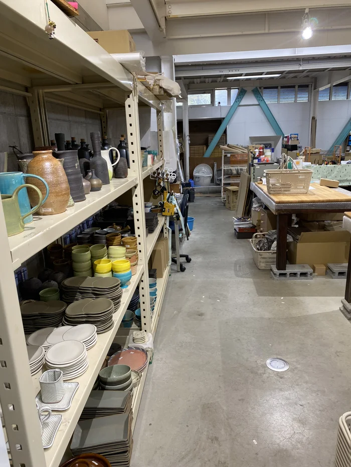倉庫風の2階フロア、棚に皿や花瓶がぎっしり