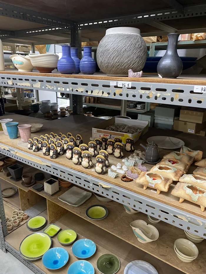 棚に花瓶や信楽焼の小さな狸がずらりと並ぶ