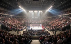 スポットライトに照らされたリングを満員の観客が取り囲むプロボクシング会場のファイトナイト全景