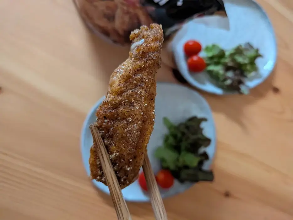 箸で持ち上げた手羽唐揚のアップ