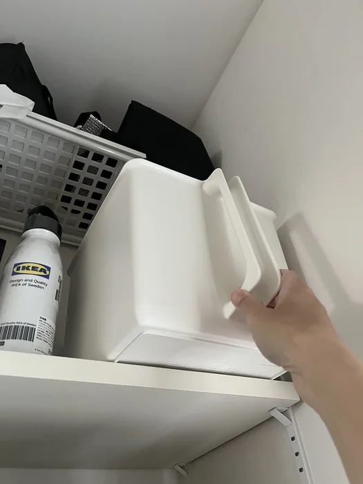 高い棚からハンドルを握って引き出す様子