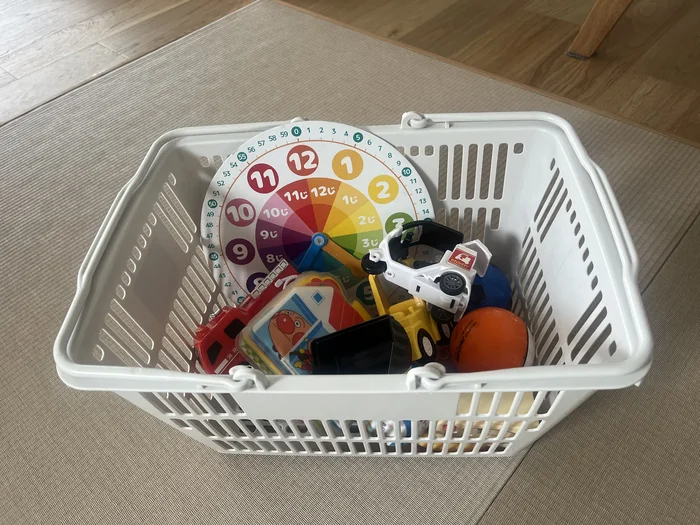 おもちゃを収納した小サイズの買い物かご