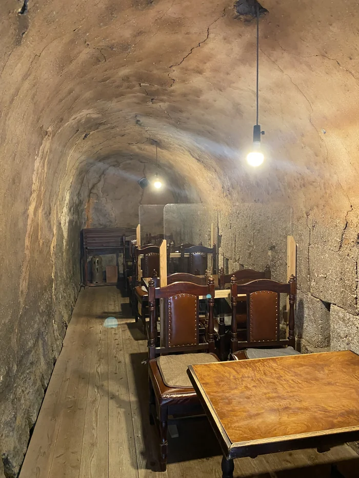 窯の中のアンティーク調のテーブルと椅子、土壁に囲まれた空間