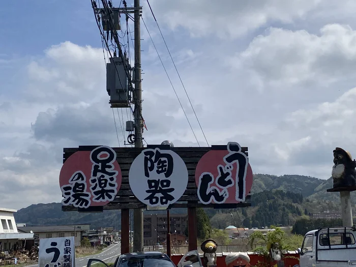 「足楽の湯・陶器・うどん」と書かれた大きな看板