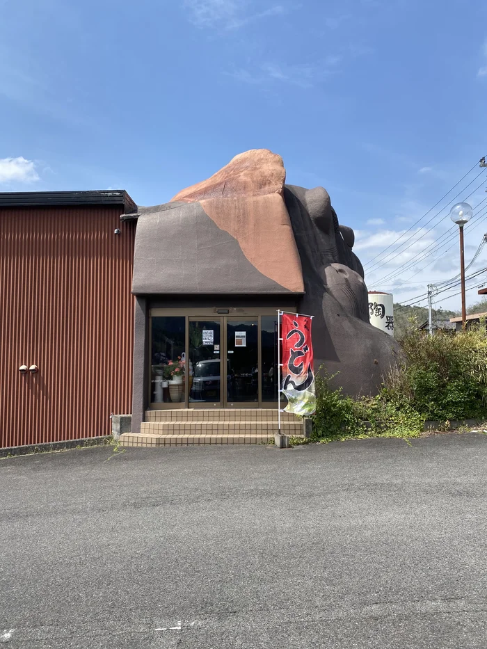 裏側のうどん屋入口、「うどん」の幟が立つ