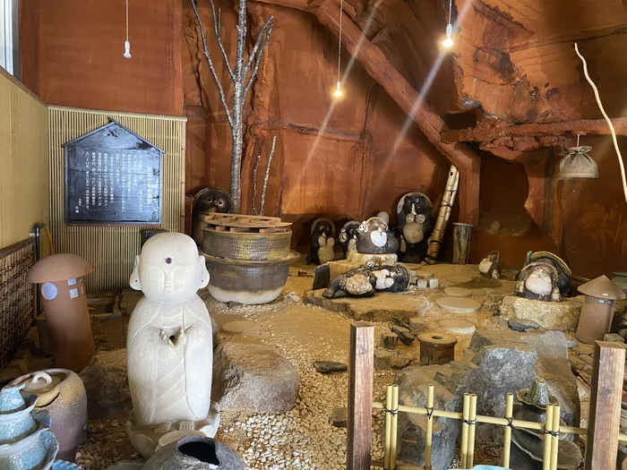 店内の狸のジオラマ風ディスプレイ、地蔵や狸の置物が並ぶ