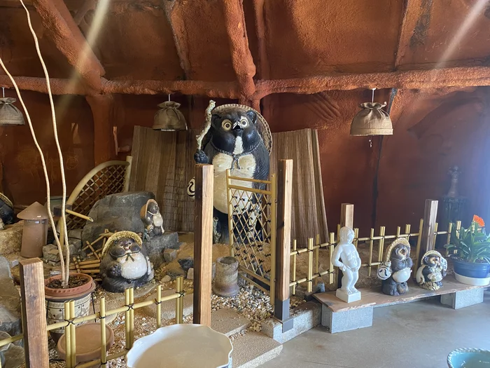 竹垣の中に並ぶ大きな信楽焼の狸の置物たち