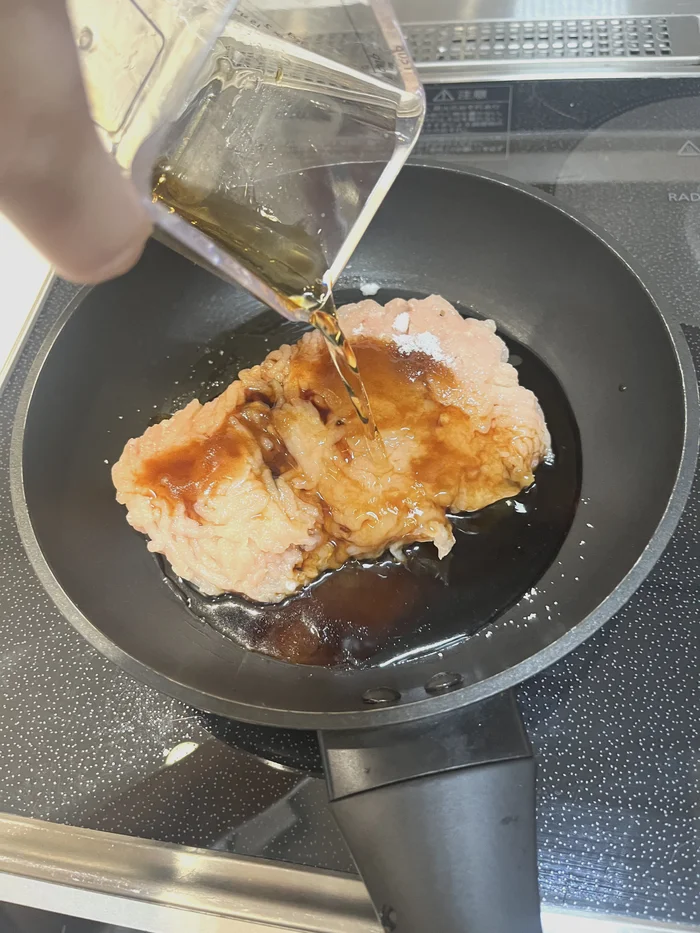 フライパンに調味料を注いでいる様子