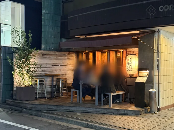 画像 夜のめっけもんの店頭、暖色照明と提灯に照らされたテラス席