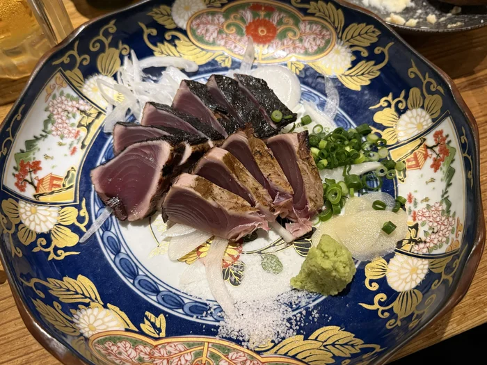 画像 めっけもんの名物カツオの藁叩き、青と金の絵柄の大皿に厚切りで盛り付け