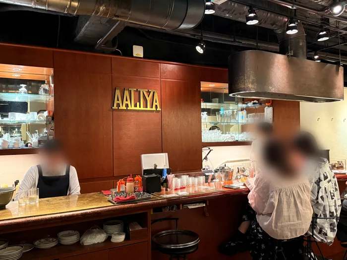 金色のAALIYAロゴが掲げられた店内のカウンター