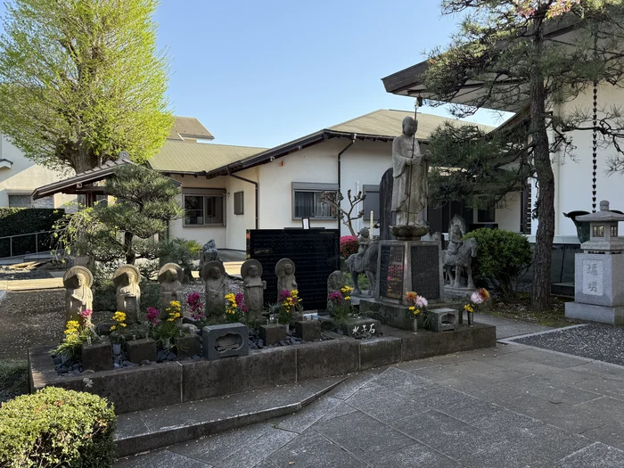 花が供えられた六地蔵と石仏が並ぶ一角