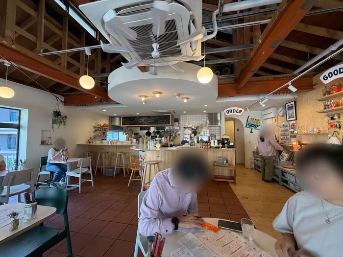 天井の梁がむき出しになった明るく開放的なカフェの店内