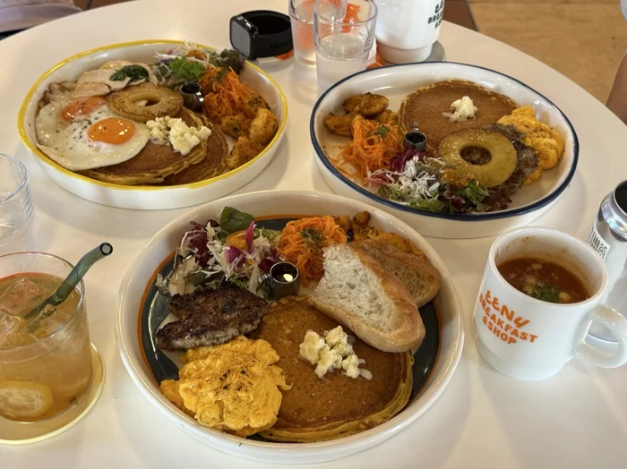 テーブルに並んだ複数の朝食プレートとスープ、ドリンク
