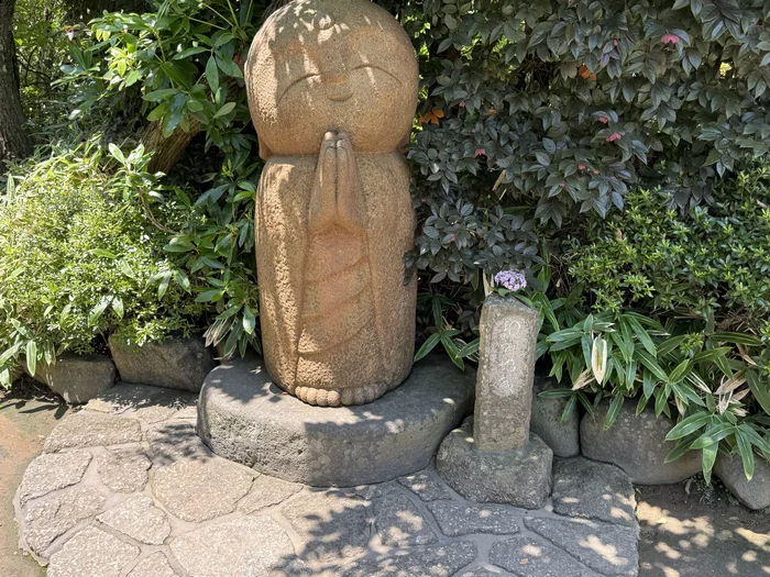 手を合わせてほほえむ、まるい姿のなごみ地蔵