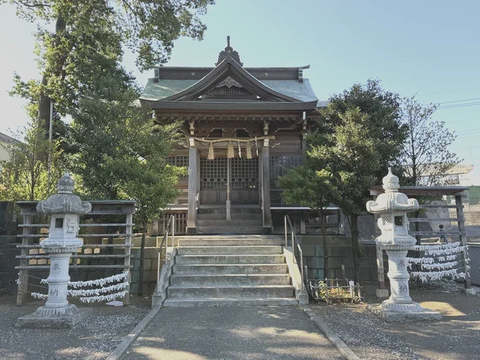 銅板葺き屋根の熊野神社の社殿と石燈籠