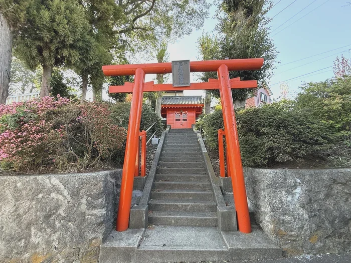 朱い鳥居と祠、手前にツツジの花