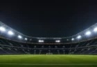 ナイターの照明に照らされた無人のサッカースタジアムとピッチ