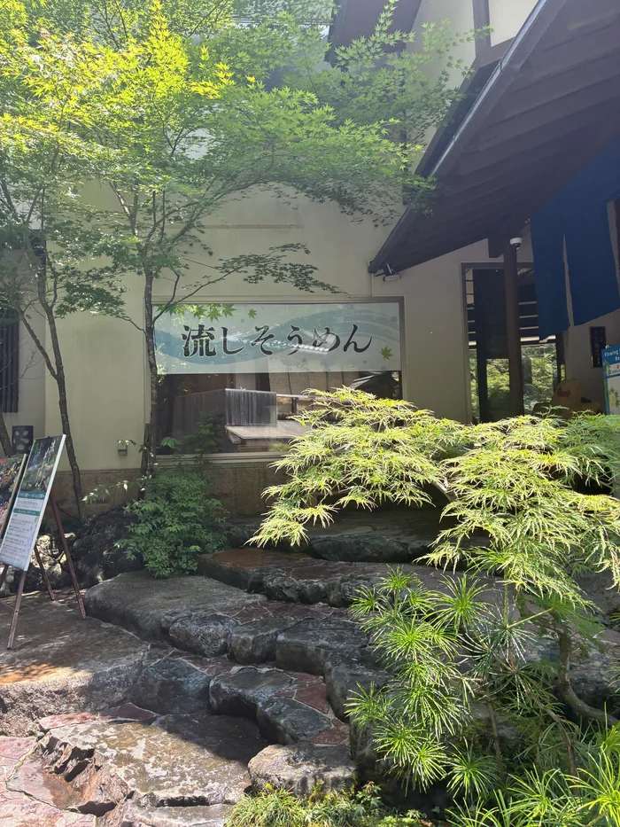 画像 流しそうめんと書かれた窓の看板と石段