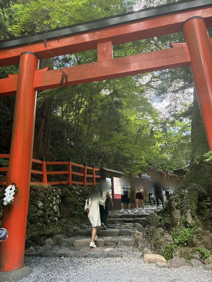 朱色の鳥居と石段を上る参拝者たち