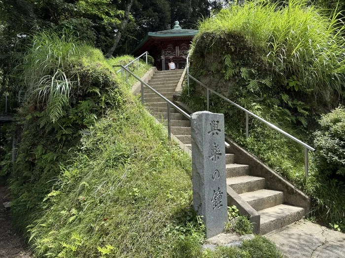 画像 興楽の鐘の石標と緑に囲まれた鐘楼へ続く石段