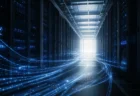 青白い光の配線が奥へと続くデータセンターの通路