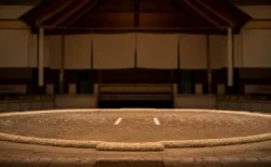 大相撲の土俵、俵と塩が撒かれた土俵面、背景に吊り屋根と垂れ幕