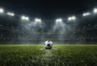 夜のサッカースタジアムでスポットライトを浴びるサッカーボール