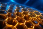 金色に輝くハニカム構造（六角形のセル）を青い光の中でクローズアップした写実的なイメージ。文字や人物は写っていない