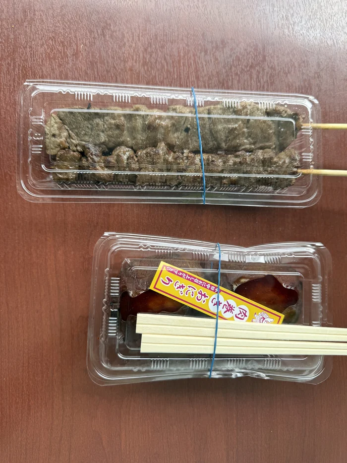 画像 テーブルに並べた牛ハラミ串と肉巻きおにぎりのパック