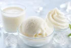 白いミルクとバニラアイス、ホイップクリームを氷とともに並べた涼しげな夏のミルクスイーツのイメージ