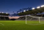 サッカースタジアムのピッチとゴールネット、夕方のナイター照明のイメージ
