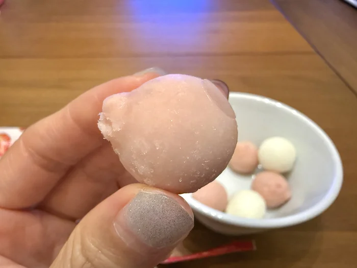 苺味のアイスの実を指でつまんだところ