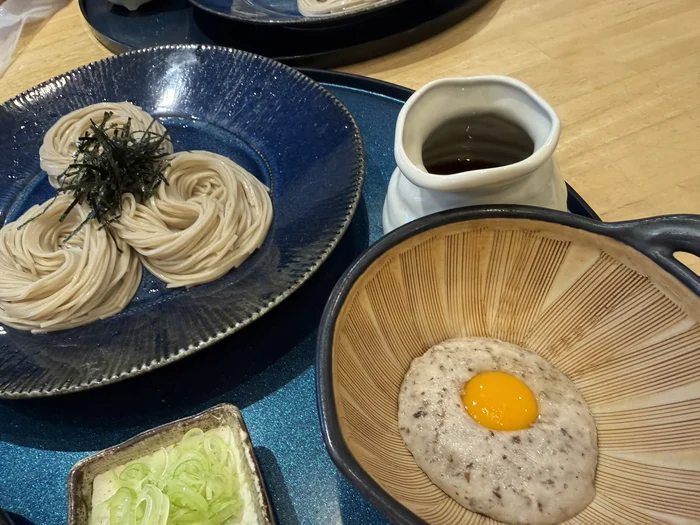 卵黄がのった自然薯と冷たい蕎麦が並ぶじねんじょとろろ蕎麦御膳のアップ