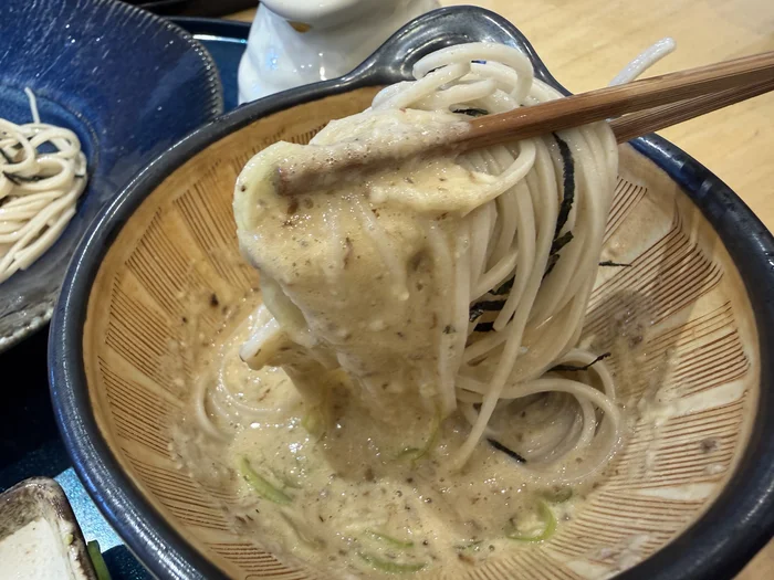 粘りの強い自然薯とろろをたっぷり絡めて箸で持ち上げた蕎麦