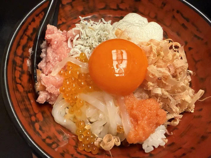 画像 ネギトロ・しらす・いくら・明太子・イカ・とろろ・かつお節・生卵の黄身をのせた海鮮のっけ丼