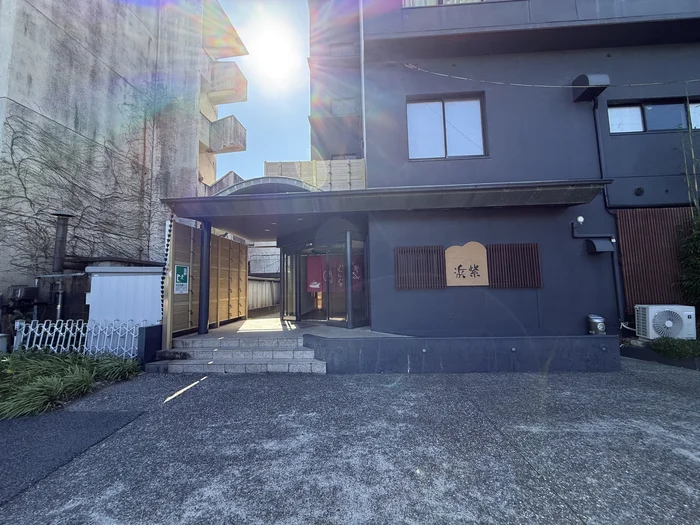 画像 木の格子とアーチ状の庇が組み合わさった宿の玄関アプローチ