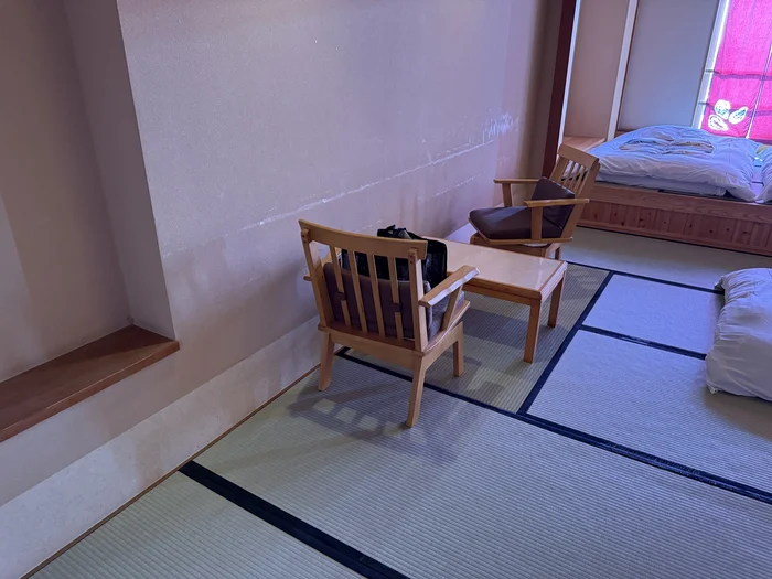 画像 客室の窓際に置かれた木製の椅子とテーブル