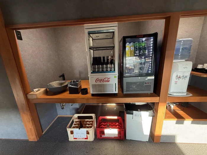 画像 冷蔵ケースとウォーターサーバーが並ぶラウンジのドリンクコーナー