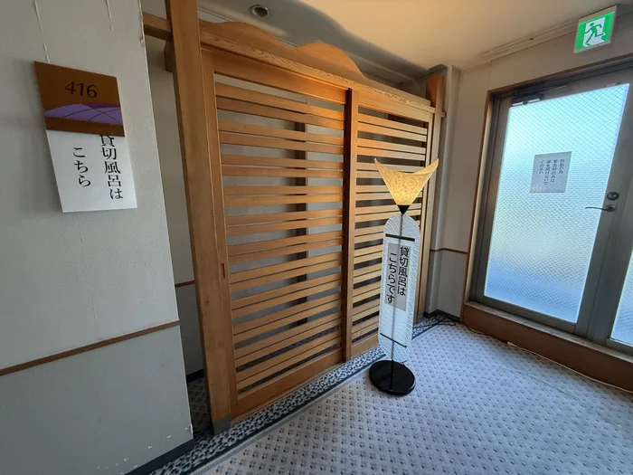 画像 416号室の前に立つ貸切風呂の案内表示と幟