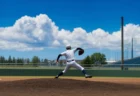夏の炎天下、マウンドで力投する高校野球投手の後ろ姿と入道雲
