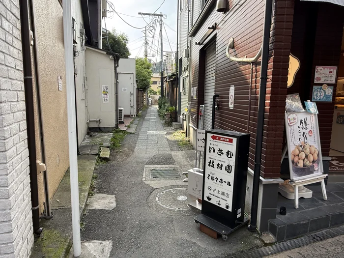小町通り側に立つ井上商店の案内看板