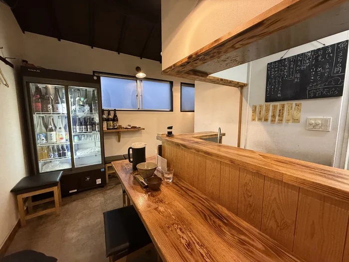 井上商店の日本酒棚と木のカウンター席