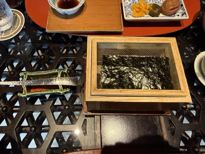 画像 木枠と金網の器に入った有明海産の焼き海苔。下に焼き石が入っている