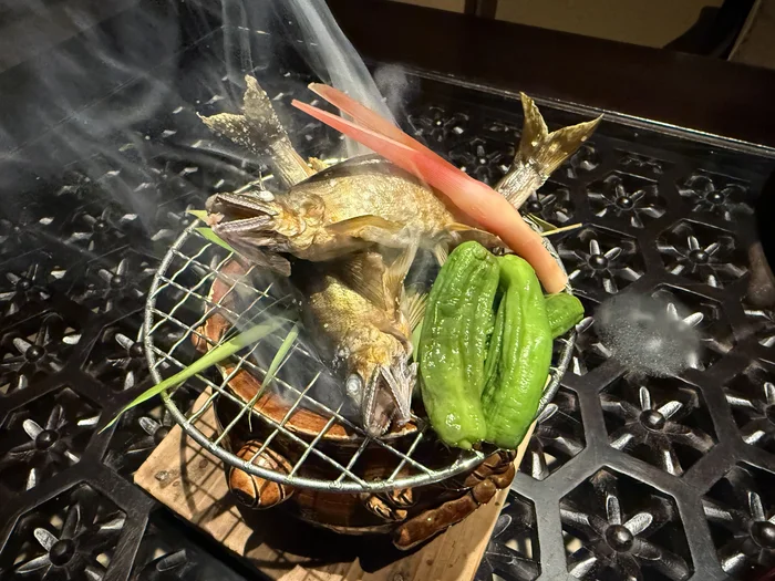 煙に包まれた状態で運ばれてきた鮎の塩焼き