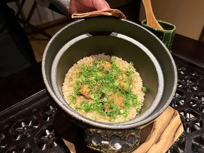 釜の蓋を開けて中の鰻の茶飯を見せているところ