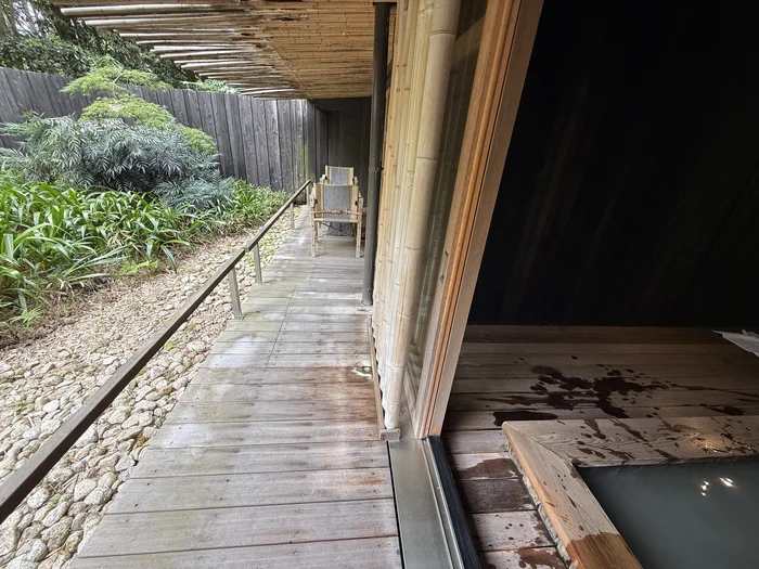 画像 客室の外側に沿って続くテラスの通路と、脇に敷かれた石と植栽