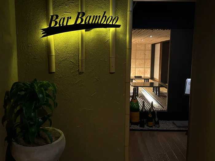 画像 間接照明に浮かぶBar Bambooの入口サインとシャンパンボトル