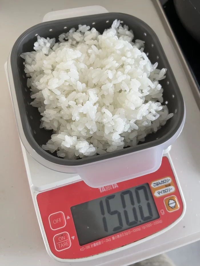 KITINTOごはん保存容器にごはんを入れてキッチンスケールで計量した様子、150gの表示